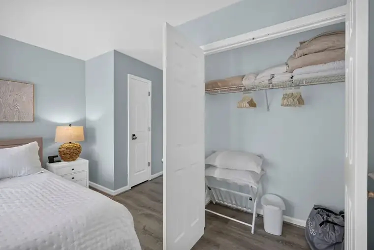 Bedroom with closet stocked with linens and towels